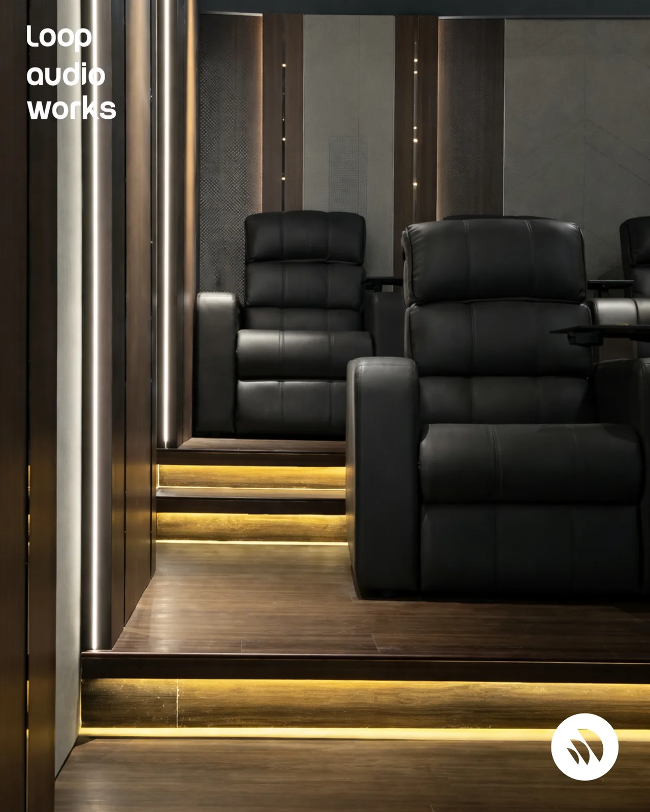 Tiered home theatre seating with custom acoustic wall treatment and ambient lighting
