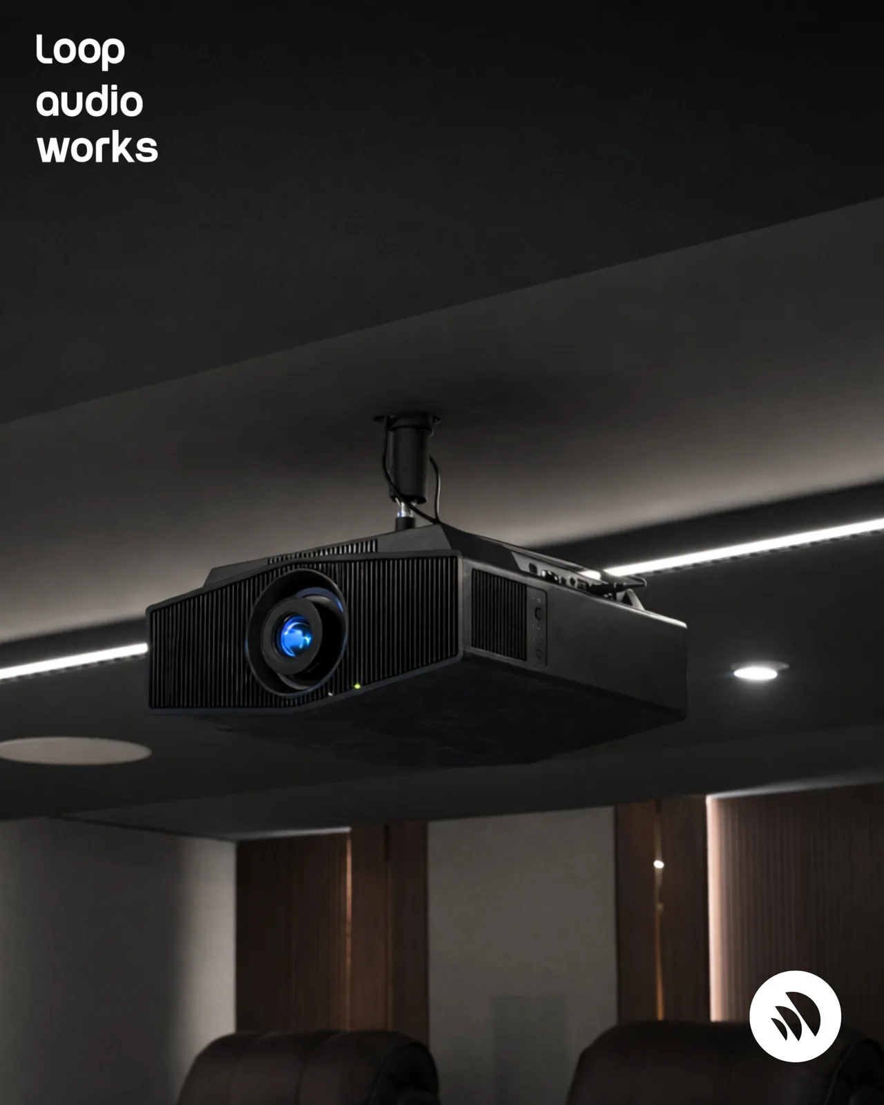 A ceiling-mounted projector installed in a finished home cinema room.