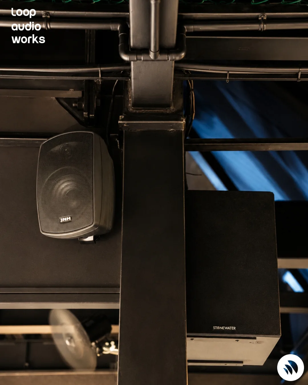 A loudspeaker mounted to a structural column, aimed into the dining floor.